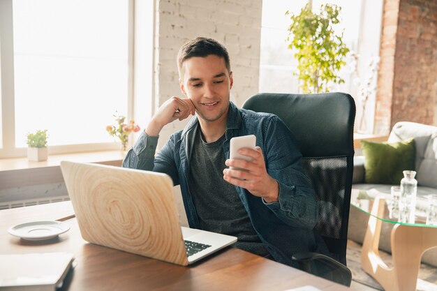 Local de trabalho criativo - espaço de trabalho organizado como você gosta para se inspirar. homem trabalhando no escritório em traje confortável, posição relaxada e mesa bagunçada. escolha a atmosfera desejada - ideal claro ou caos.