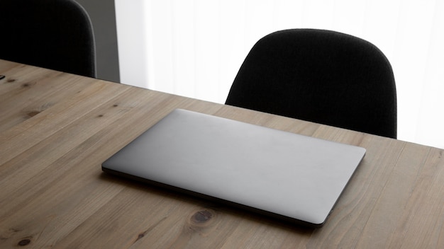 Foto grátis local de trabalho de alto ângulo com laptop e cadeiras