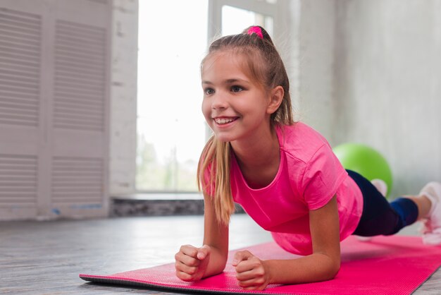 Loira jovem sorridente fazendo exercícios de fitness