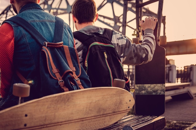 Foto grátis longboard e mochila em um banco em uma cidade.