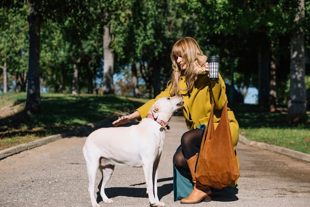 Foto grátis lovely woman with thermos petting dog