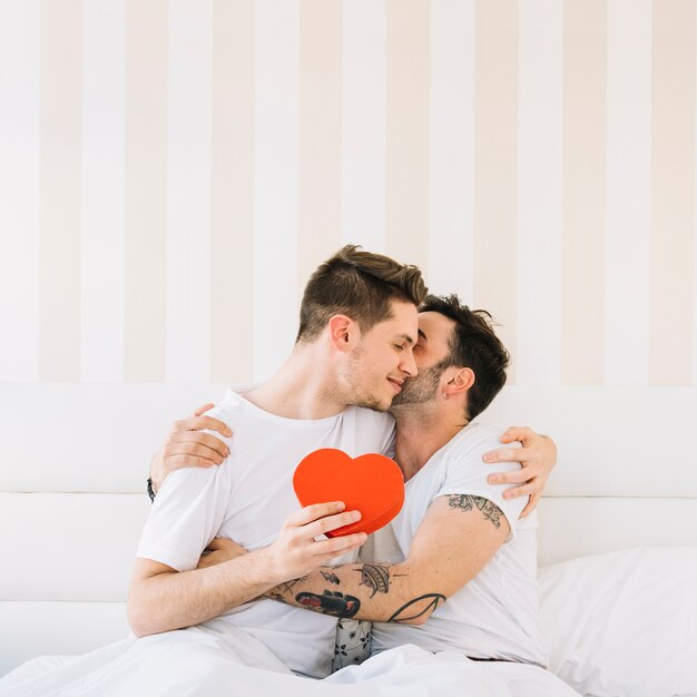 Loving gay couple posando na cama