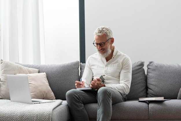 Último homem em casa estudando no laptop e fazendo anotações