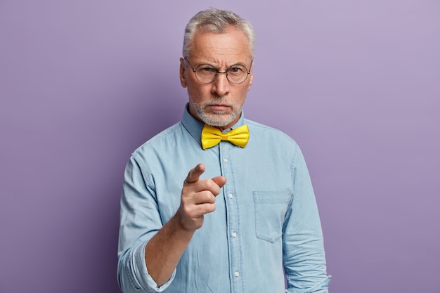 Último homem vestindo camisa azul e gravata borboleta amarela