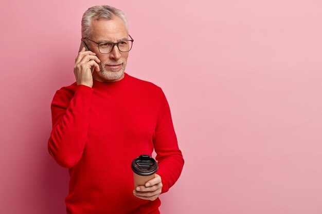 Último homem vestindo um suéter vermelho e falando ao telefone
