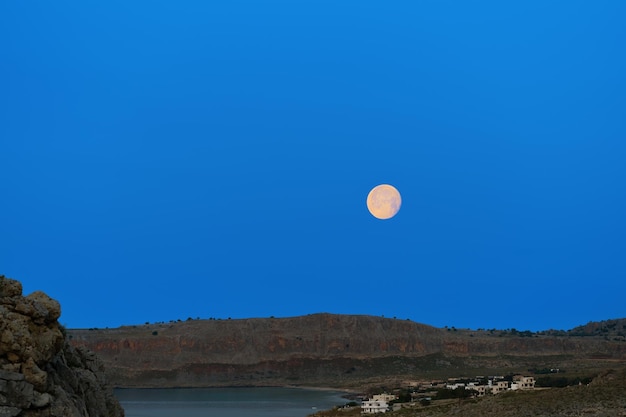Lua cheia no início da manhã antes do nascer do sol ilha de rodes cenário magnífico nas ilhas gregas do arquipélago do dodecaneso, um famoso destino de férias e viagens