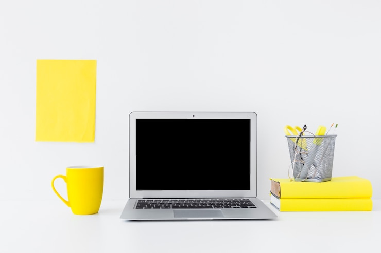 Foto grátis lugar de trabalho elegante com laptop e detalhes amarelos