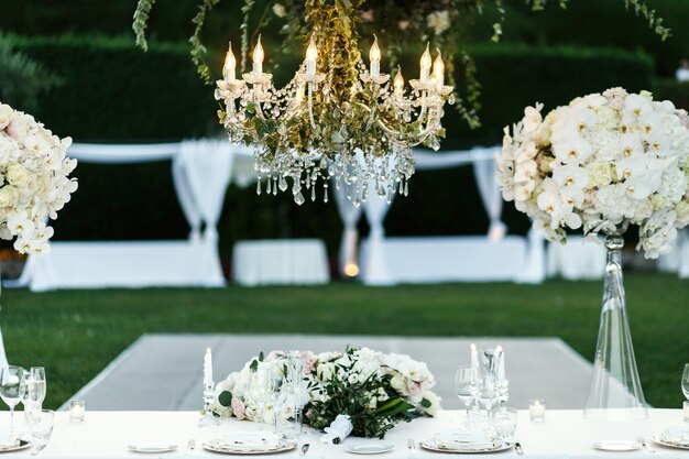 Lustre com flores e vegetação paira sobre a mesa de jantar