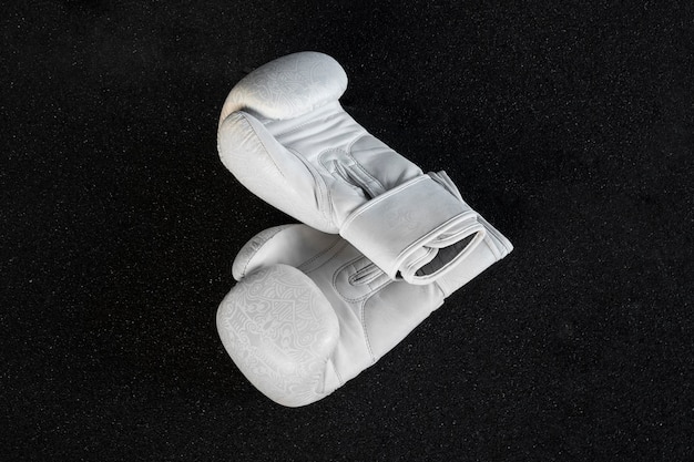 Foto grátis luvas de boxe brancas com fundo escuro