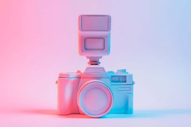 Luz azul vintage pintou a câmera rosa contra o pano de fundo-de-rosa