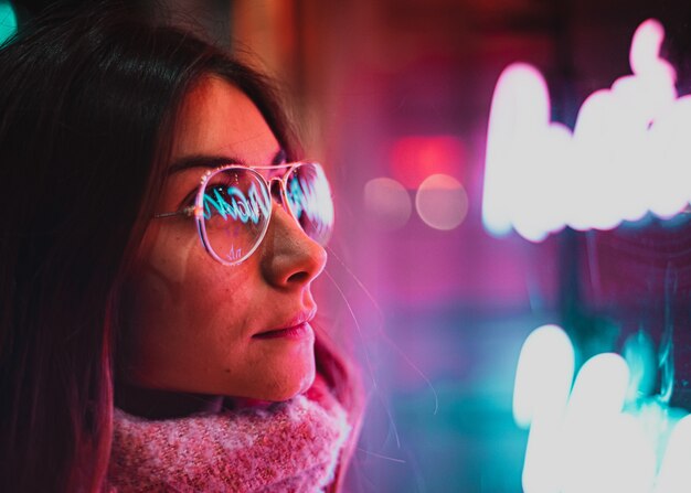 Luz neon refletida nos óculos femininos