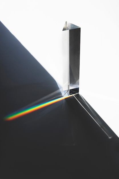 Foto grátis luz que passa através de um prisma triangular com sombra escura na superfície branca