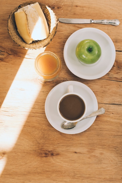 Luz solar sobre o café da manhã no plano de fundo texturizado de madeira