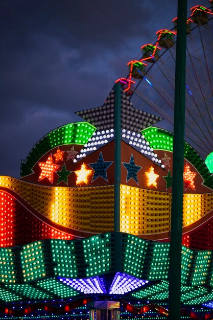 Luzes de néon coloridas em formas de estrela no fundo da roda gigante