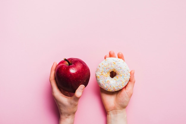 Foto grátis maçã e donut no pano de fundo rosa