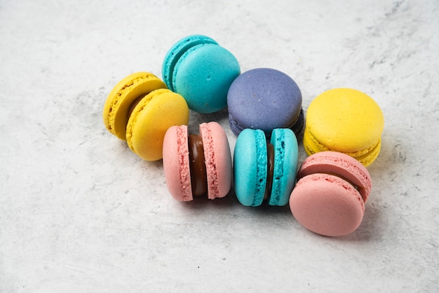 Macarons de amêndoa coloridos na superfície branca. fechar-se.