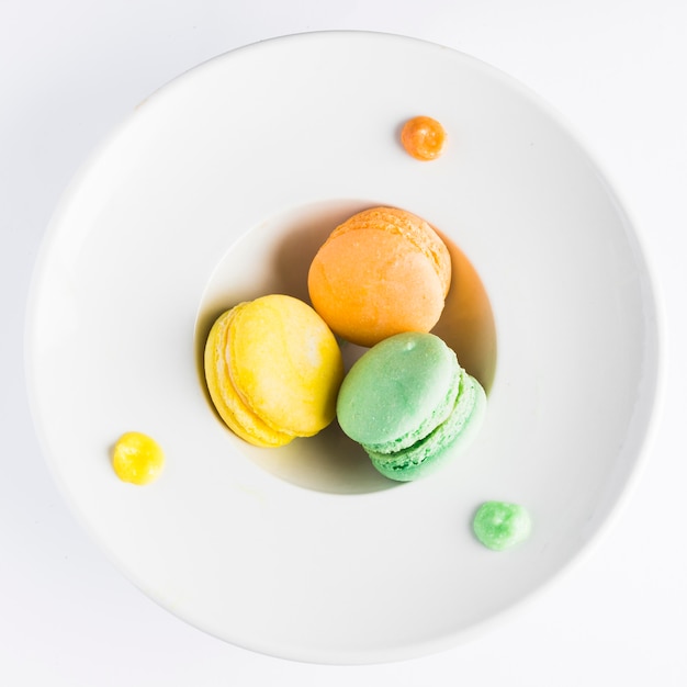 Foto grátis macarons de configuração plana em prato fundo