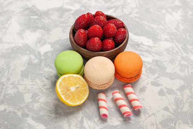 Macarons franceses com morangos frescos na superfície branca, frutas, bolo, biscoito doce açúcar