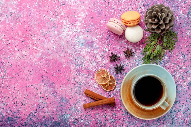 Macarons franceses de cima, deliciosos bolinhos com chá na superfície rosa