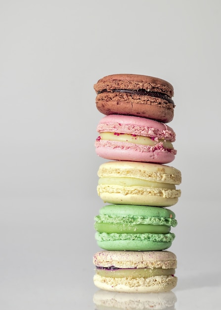 macaroons coloridos uns sobre os outros em uma mesa contra um fundo branco