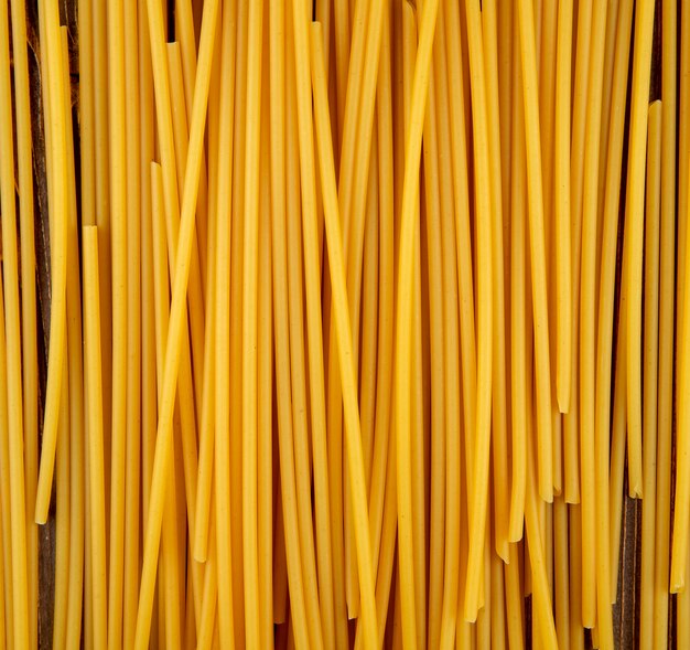 Macarrão bucatini de vista superior em fundo de madeira