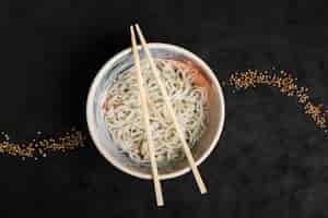 Foto grátis macarrão caseiro de udon de comida japonesa com design de sementes de coentro em fundo preto