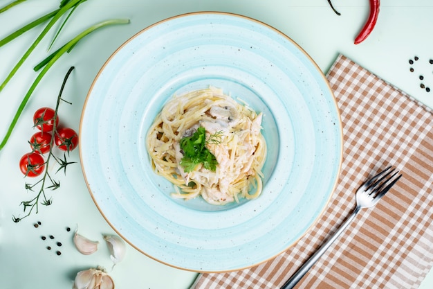 Macarrão coberto com creme de leite e cogumelos