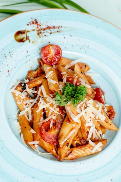 Macarrão coberto com tomate, queijo e ervas