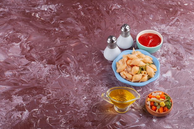 Macarrão com casca italiana com molho de tomate e salada mista de vegetais na mesa de luz.