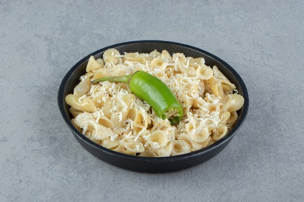 macarrão com queijo ralado na chapa preta.