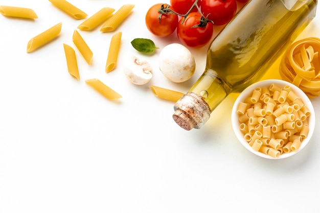 Foto grátis macarrão cru com azeite de oliva tomate e cópia espaço