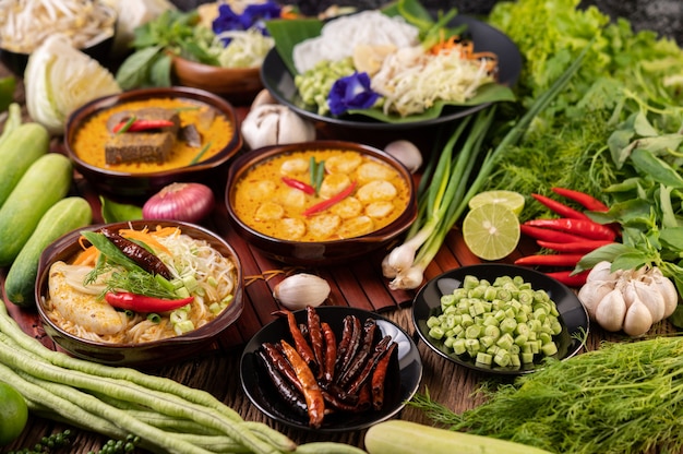 Foto grátis macarrão de arroz, curry vermelho com almôndegas, com pimentões secos, manjericão, pepino e feijão comprido