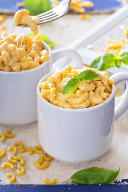 Macarrão e queijo servidos em canecas