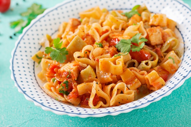 Macarrão em forma de coração com frango e tomate em molho de tomate.