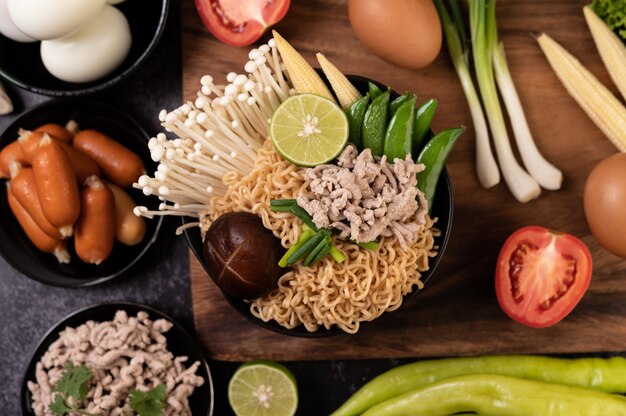 Macarrão instantâneo com carne de porco picada, limão, cebola, ervilha, cogumelo dourado e milho bebê