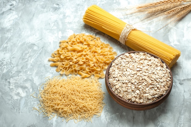 Macarrão italiano comprido de frente com massa pequena crua em formato diferente em cor de comida clara, muitos tipos de massa