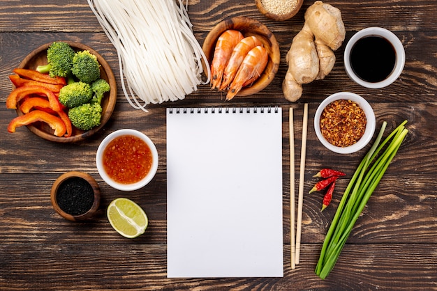 Macarrão liso leigos especiarias e pauzinhos com caderno em branco