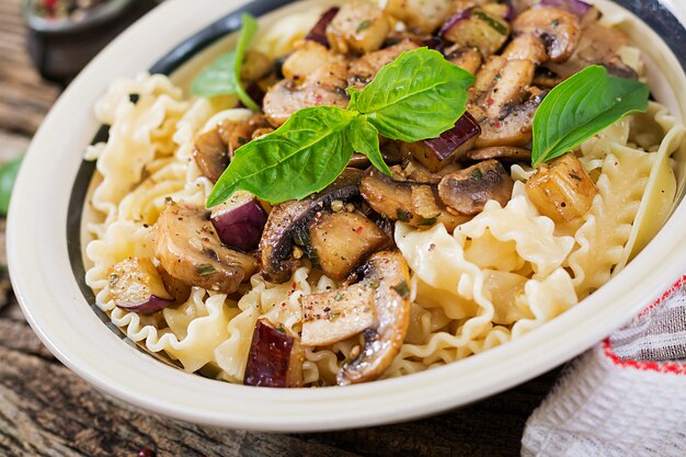 Macarrão vegetariano com cogumelos e beringelas, berinjelas. Comida italiana. Refeição vegana.