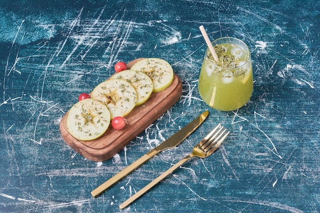 Maçãs verdes e suco em azul.