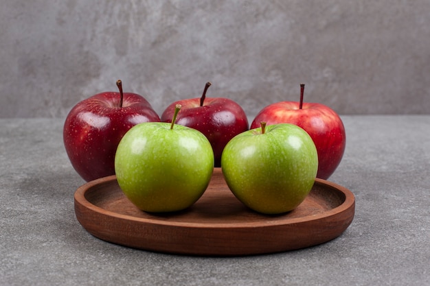 Foto grátis maçãs verdes e vermelhas na mesa de madeira da cozinha