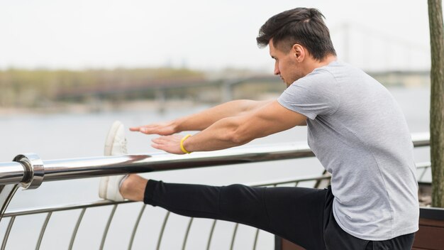 Foto grátis macho adulto aquecendo antes de correr