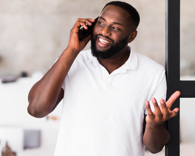 Macho adulto bonito falando ao telefone