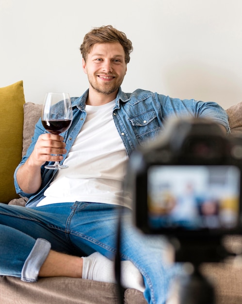 Foto grátis macho adulto, gravando-se com copo de vinho