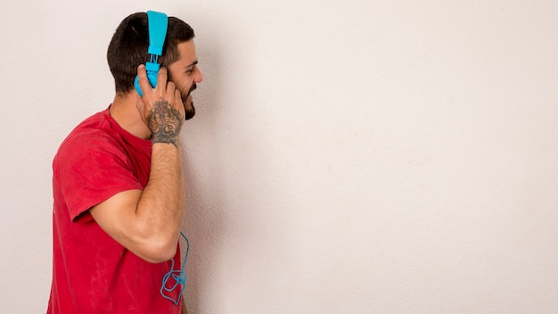 Foto grátis macho barbudo escuta música com fones de ouvido