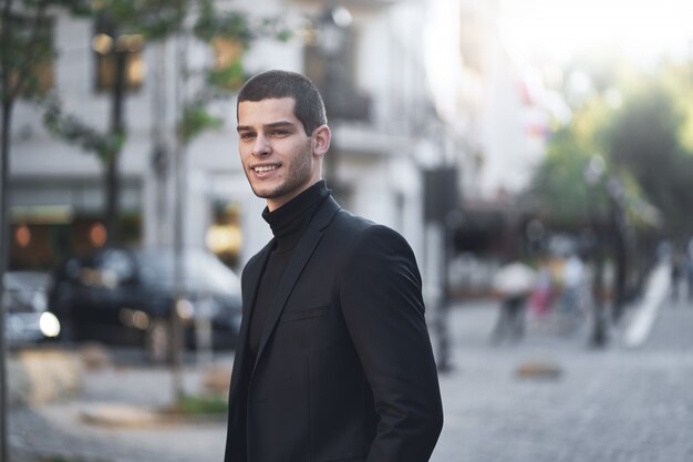 Macho jovem bonito andando na rua