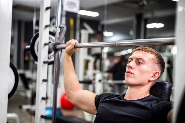 Macho jovem close-up no treinamento de ginástica para braços