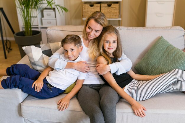 Mãe abraçando seu filho e filha