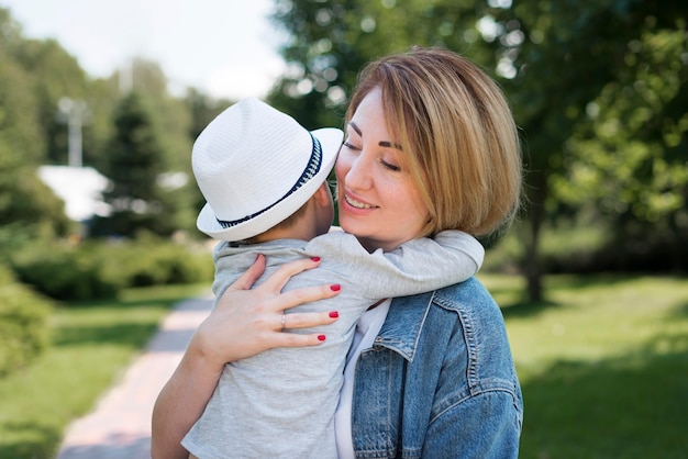 Mãe abraçando seu filho tiro médio