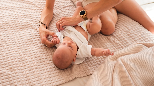 Mãe adorável que veste recém-nascido