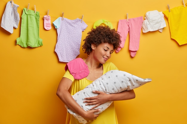 Foto grátis mãe afetuosa abraça bebê adormecido enrolado em cobertor, expressa amor e carinho ao bebê, cuida do recém-nascido, sendo mãe feliz, conversa com sua filhinha, segura criança pequena nos braços